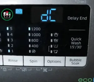 Close-up of a Samsung washing machine digital display showing an alphanumeric error code being tested by an electronic specialist from Appliances Fix Dubai.